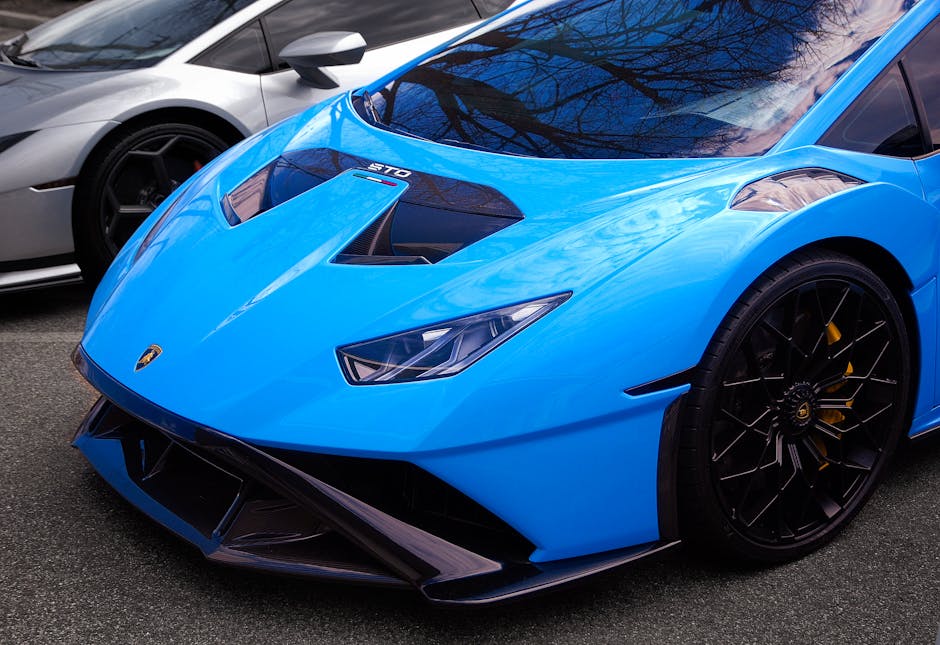 Close-up of a sleek blue sports car with striking design details, parked outside.