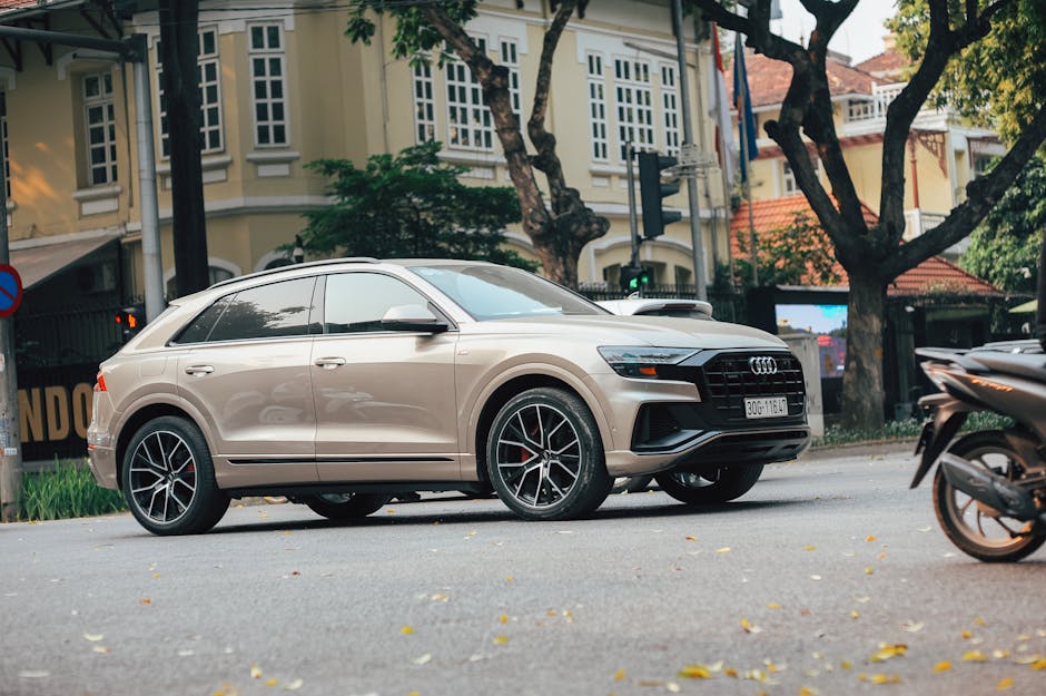 A beige luxury SUV is parked on a quiet city street, showcasing elegance and style