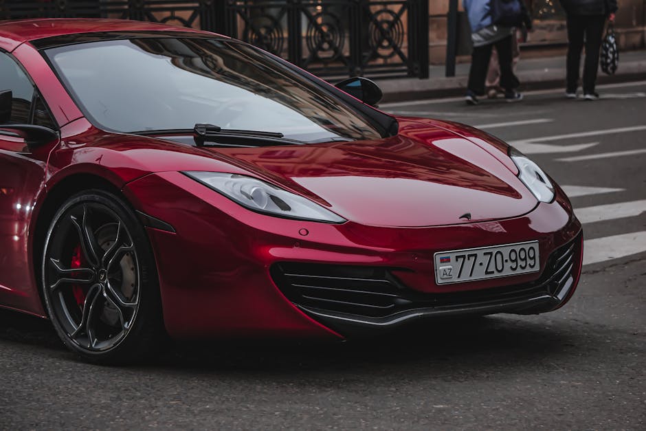 A luxurious red sports car parked on a city street, showcasing its sleek design and modern aesthetics.